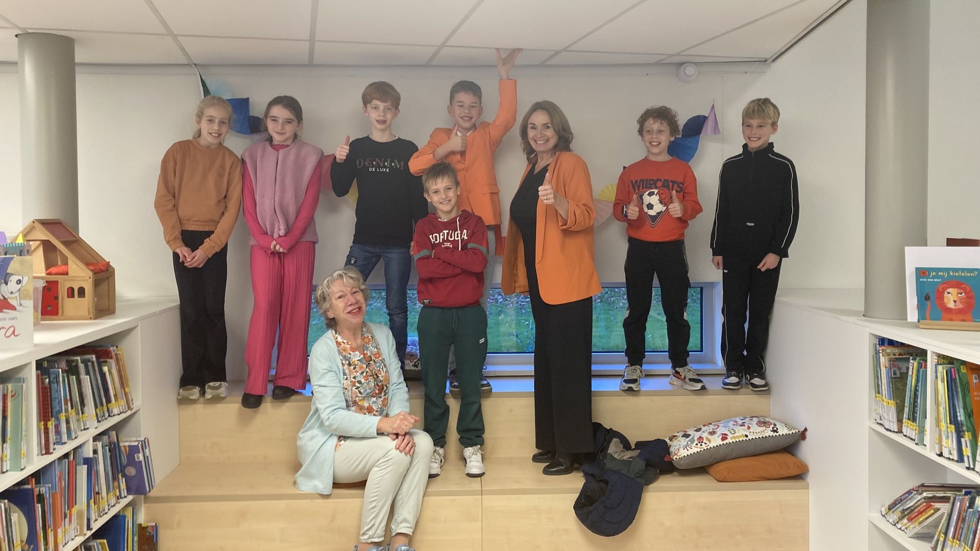Bart (in oranje blazer) en Renske van Kooij met een groep kinderen.