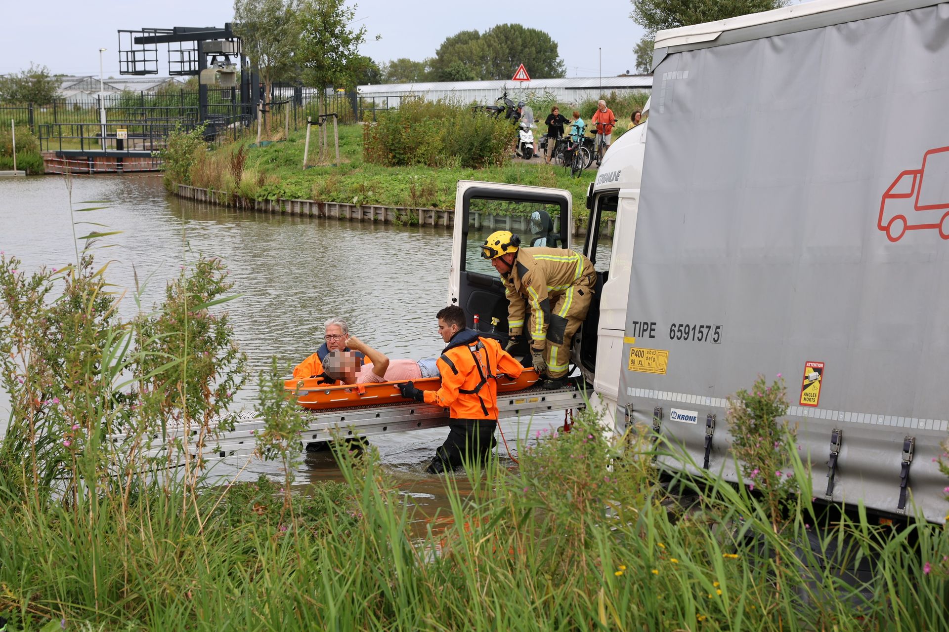 De brandweer redt de chauffeur uit zijn vrachtwagen.