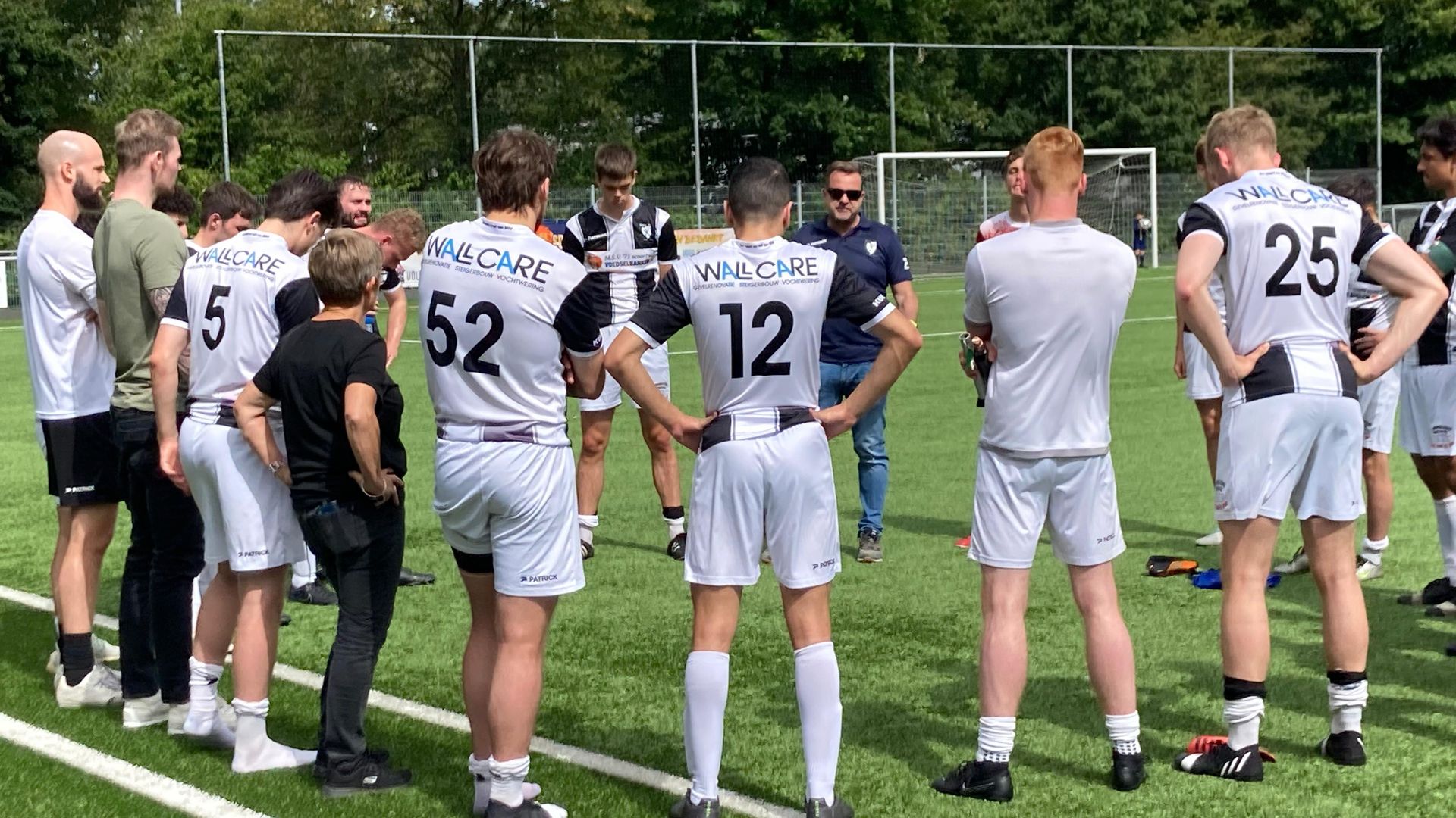 MSV-spelers druipen af en trainer Paul van Loenen spreekt zijn mannen toe na de degradatie