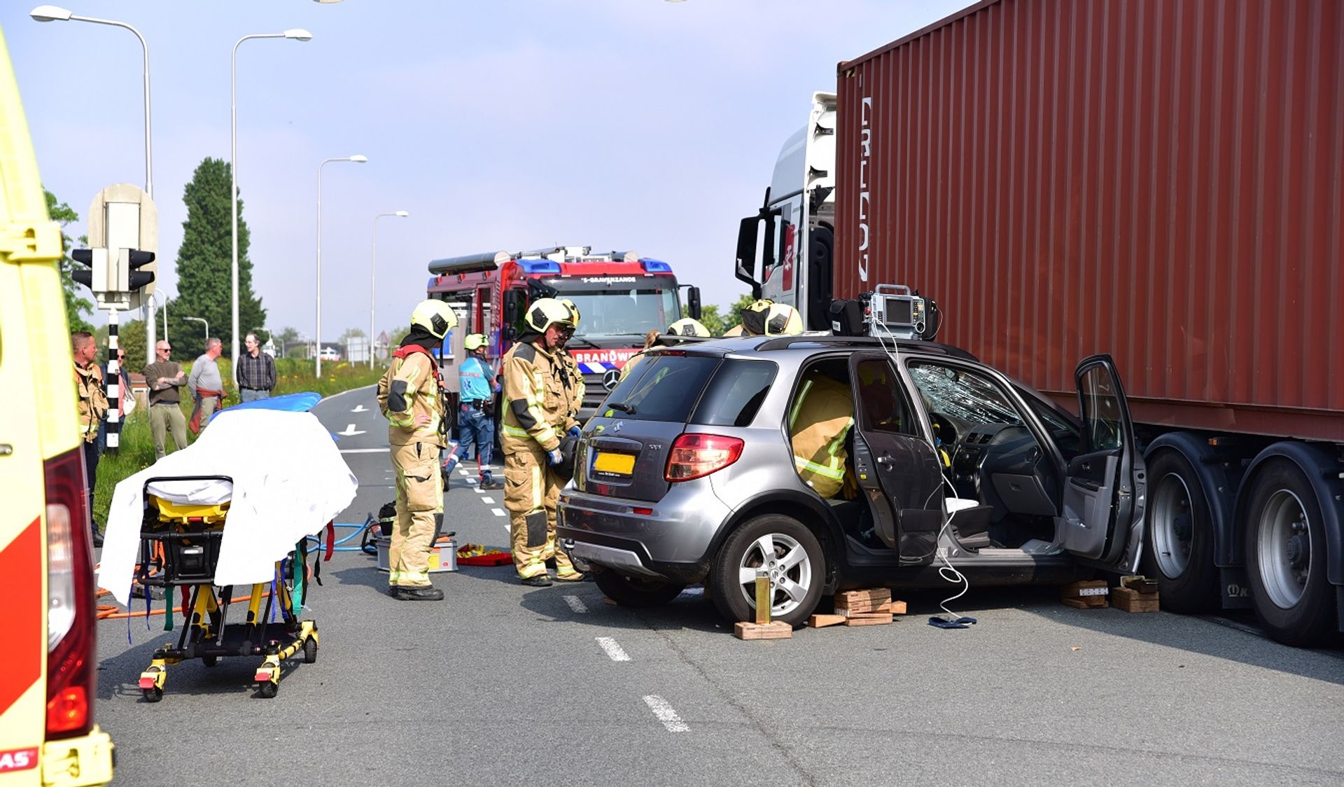 Personenauto klem onder trailer